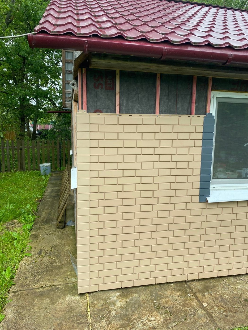 Общий вид здания или деталь облицовки фасадными панелями под кирпич.
